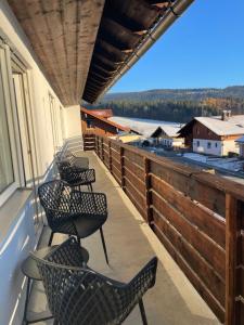 ein Balkon mit Stühlen und Blick aufs Wasser in der Unterkunft Ferienwohnung Müller - Arberblick in Lohberg