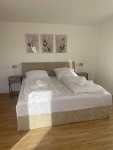 ein weißes Bett mit zwei weißen Kissen darauf in der Unterkunft Ferienwohnung Müller - Arberblick in Lohberg + 4 Fotos