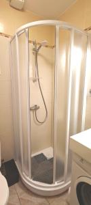 a shower with a glass door in a bathroom at City center apartment in Klaipėda