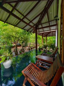 a patio with two chairs and a table and a pool at Bright Sun Safari in Udawalawe
