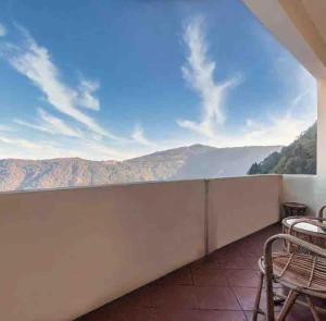 einen Balkon mit Stühlen und Bergblick in der Unterkunft Daphne House in Darjeeling