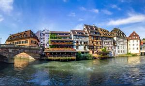een groep gebouwen naast een rivier met een brug bij Euro Mobil B16 in Boofzheim