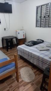 une chambre avec un lit, une table et une chaise dans l'établissement Pousada Doce Lar, à Camanducaia