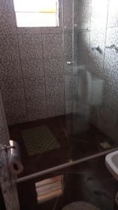 une salle de bain avec une douche avec des toilettes et un lavabo dans l'établissement Pousada Doce Lar, à Camanducaia