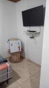 Cette chambre dispose d'une télévision et d'une boîte sur une table. dans l'établissement Pousada Doce Lar, à Camanducaia