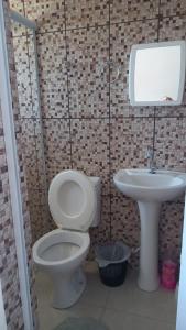 une salle de bains avec toilettes et lavabo dans l'établissement Pousada Doce Lar, à Camanducaia