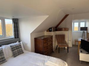 une chambre avec un lit, un bureau et une chaise dans l'établissement Cottage on remote wild coast, à Bawdsey