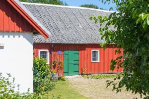 Un granero rojo y verde con una puerta verde. en Toftalid, en Sjöbo