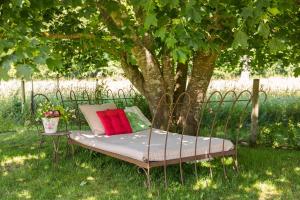 Una cama sentada en el césped debajo de un árbol. en Toftalid, en Sjöbo