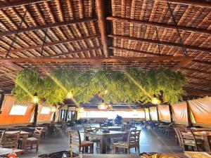 a restaurant with tables and chairs and a wooden ceiling at Lonier Villa Inn Economic in Abraão
