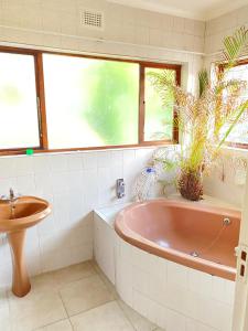 a bathroom with a tub and a sink at LaPoch Guesthouse in Durban