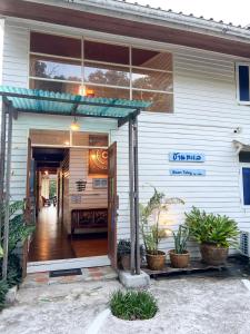 ein weißes Haus mit Pflanzen davor in der Unterkunft Baan Talay Koh Chang in Ban Map Khangkhao