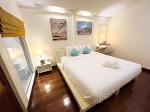 ein Schlafzimmer mit einem großen weißen Bett mit blauen Kissen in der Unterkunft Baan Talay Koh Chang in Ban Map Khangkhao