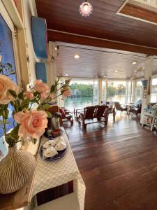 ein Wohnzimmer mit einem Tisch mit Blumen darauf in der Unterkunft Baan Talay Koh Chang in Ban Map Khangkhao