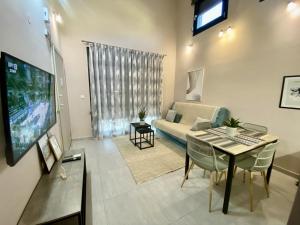 een woonkamer met een bank en een tafel bij Modern Living Experience in Néa Péramos