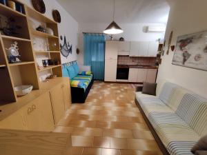 a living room with a couch and a kitchen at Cottage84Milazzo in Milazzo