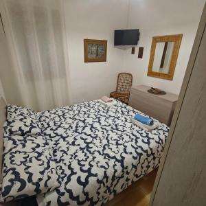 a bedroom with a bed with a black and white comforter at Cottage84Milazzo in Milazzo
