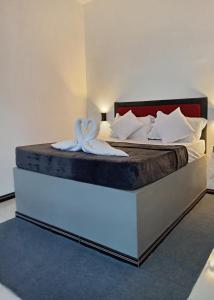 a bedroom with a bed with a whitevisorvisorvisor at Ravan Pine Nature Retreat in Ella