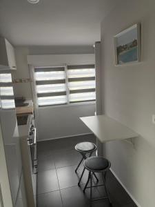 桑坦德Ático recién reformado en Santander的一间厨房,里面设有两张凳子和一个柜台 更多3张照片