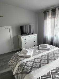桑坦德Ático recién reformado en Santander的一间卧室配有一张床和一个带电视的梳妆台