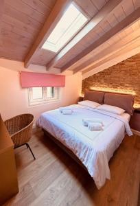 a bedroom with a large bed with two towels on it at L'Atelier TOP LOCATION in Corfu