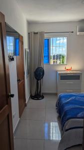 a bedroom with a bed and a desk and a window at Mitaly Apartamentos 111 in Santo Domingo