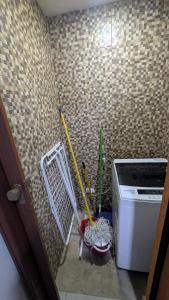 a corner of a room with cleaning tools and a washing machine at Mitaly Apartamentos 111 in Santo Domingo