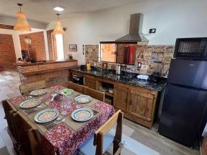 a kitchen with a table with plates on it at Cabaña Premium Ñakurutu de La Mala Junta in Atyrá