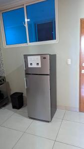 a small refrigerator in a room with a window at Mitaly Apartamentos 111 in Santo Domingo