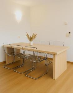 奥斯坦德Relaxed coastal stay - steps from beach & center的一张带椅子的木桌和一盆盆植物