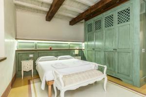 una camera con letto bianco e armadi verdi di 2 minuti dal Duomo - Parcheggio free a 3 minuti ad Arezzo