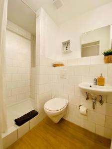 a white bathroom with a toilet and a sink at Pension Garni No.11 in Dresden +23 photos