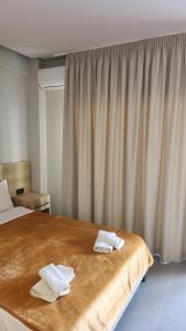 une chambre avec un lit avec deux serviettes dessus dans l'établissement VILA NIKOLETA, à Ierissos
