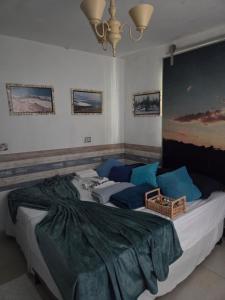Un dormitorio con una cama grande con almohadas azules. en Flat Lagoa Azul, en Maragogi