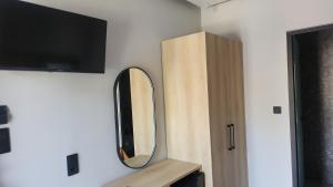un miroir sur un mur à côté d'une armoire en bois dans l'établissement VILA NIKOLETA, à Ierissos