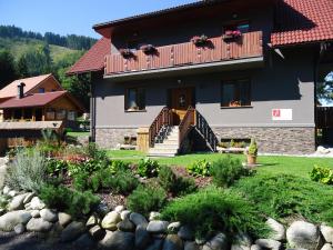 a house with a garden in front of it at Apartmány Lipka in Pavčina Lehota