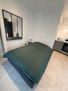 Una cama grande en una habitación blanca con un espejo. en Brest Centre Studio, en Brest