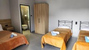 une chambre d'hôtel avec deux lits et une salle de bain dans l'établissement VILA NIKOLETA, à Ierissos