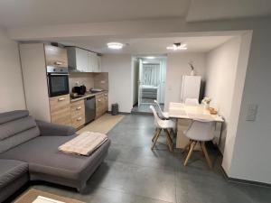 a living room with a couch and a table and a kitchen at Wohnung in Metzingen +4 photos