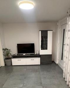 uma sala de estar com uma TV de tela plana na parede em Wohnung em Metzingen