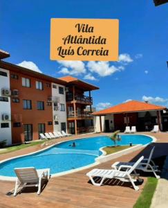 une piscine avec deux chaises longues et un hôtel dans l'établissement FLAT 104 Luis Correia Vila Atlântida, à Luis Correia