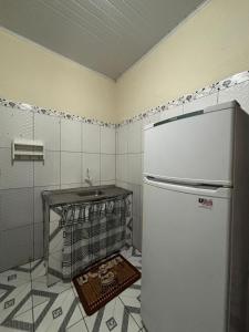 een keuken met een witte koelkast en een tegelvloer bij Casa da Missi in Cayru