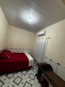 een slaapkamer met een rood bed in een kamer bij Casa da Missi in Cayru