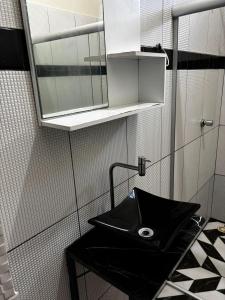 een badkamer met een zwarte wastafel en een spiegel bij Casa da Missi in Cayru