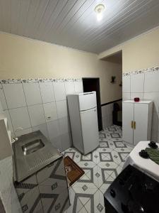 een keuken met 2 koelkasten en een tegelvloer bij Casa da Missi in Cayru