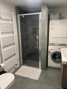um banheiro com chuveiro e máquina de lavar em Wohnung em Metzingen