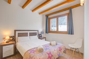 a bedroom with a bed and a window and a chair at Andorra Family Snow Apartment - Happy Rentals in El Tarter
