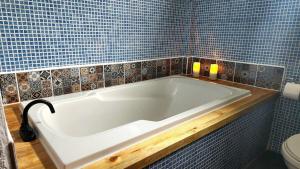 圣佩德罗拉拉古纳Views, Booze & Family Feuds! Chisme Not Included的浴室设有浴缸,铺有蓝色瓷砖。 更多29张照片