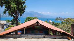 圣佩德罗拉拉古纳Views, Booze & Family Feuds! Chisme Not Included的一座带红色屋顶的建筑,享有水景