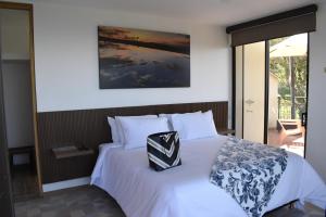une chambre avec un lit blanc avec un oreiller dessus dans l'établissement Hotel Casa Portones, à San Bernardo